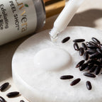 Exfoliating product being applied to skin with black rice seeds nearby, featuring the Livera brand.