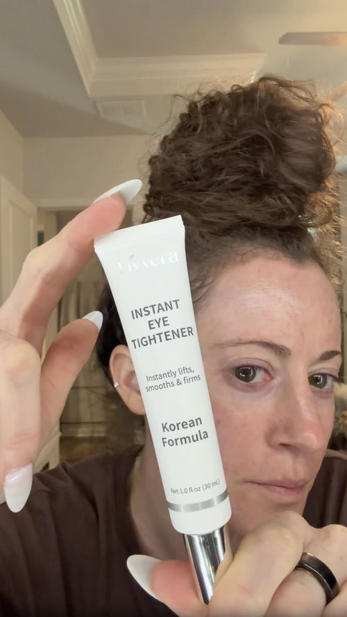 Person holding a skincare product labeled 'Instant Eye Tightener' in front of their face.