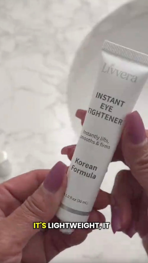Tube of Livvera Instant Eye Tightener held by a hand with purple nail polish on a light background.