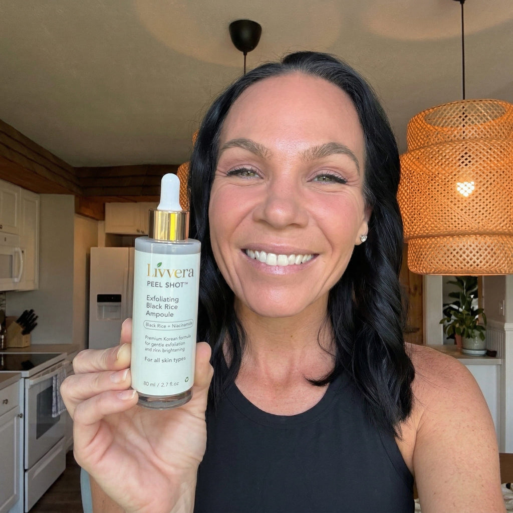 Woman holding a skincare product in a kitchen setting