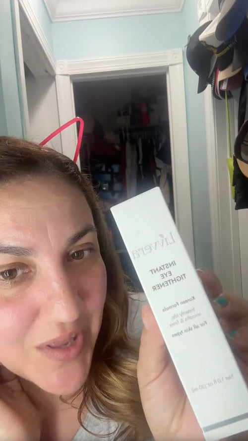 Woman holding a skincare product box in front of a mirror