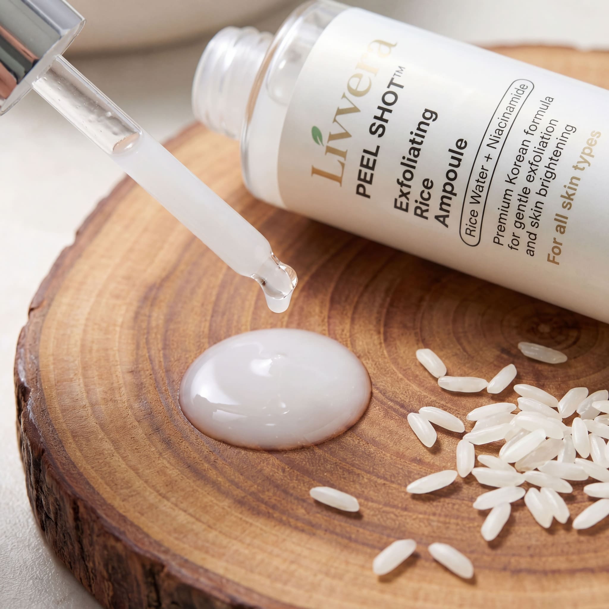 Exfoliating Rice Ampoule bottle with dropper on a wooden surface with rice grains.